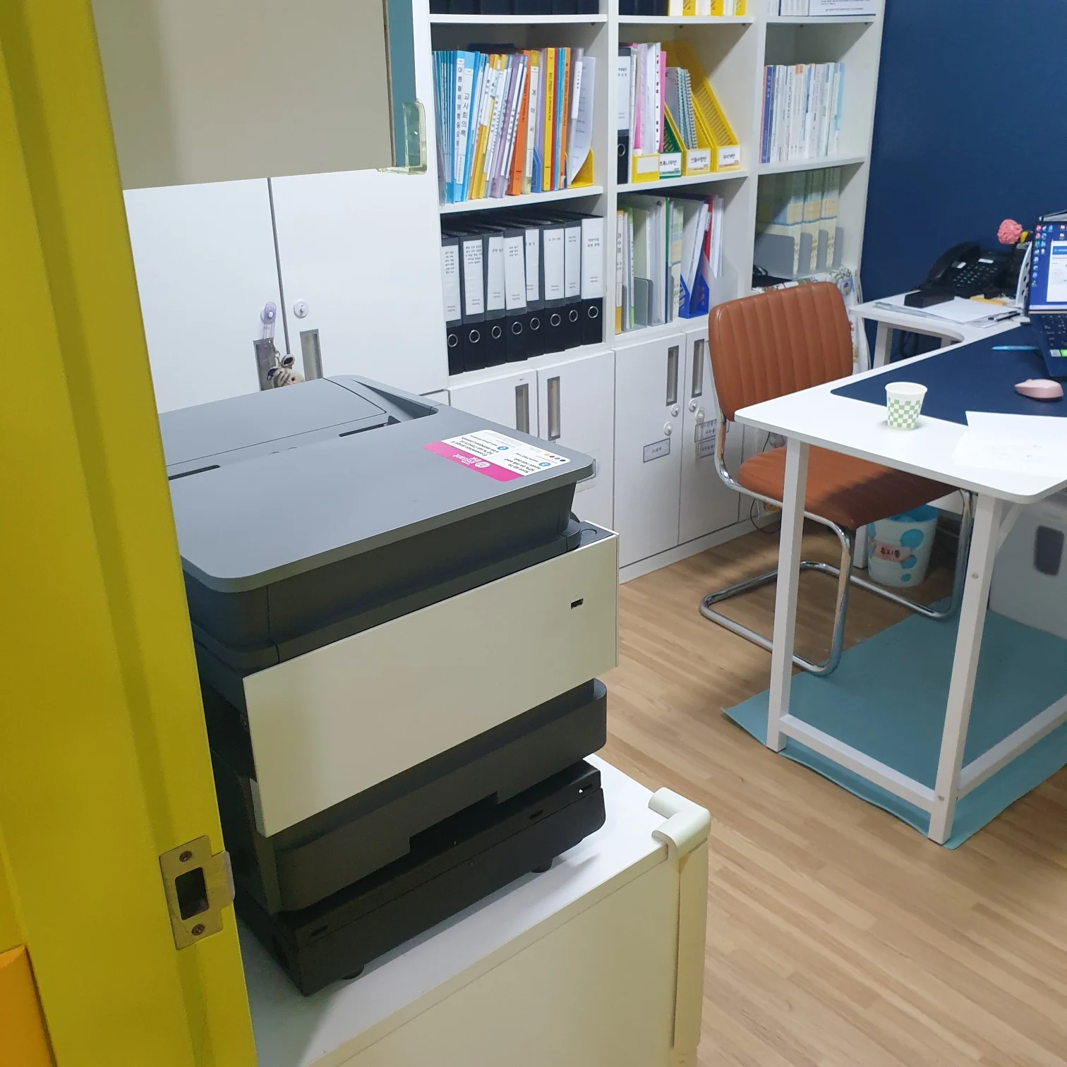 용인 사무공간에 놓인 HP9010 복합기 뒷모습과 책장